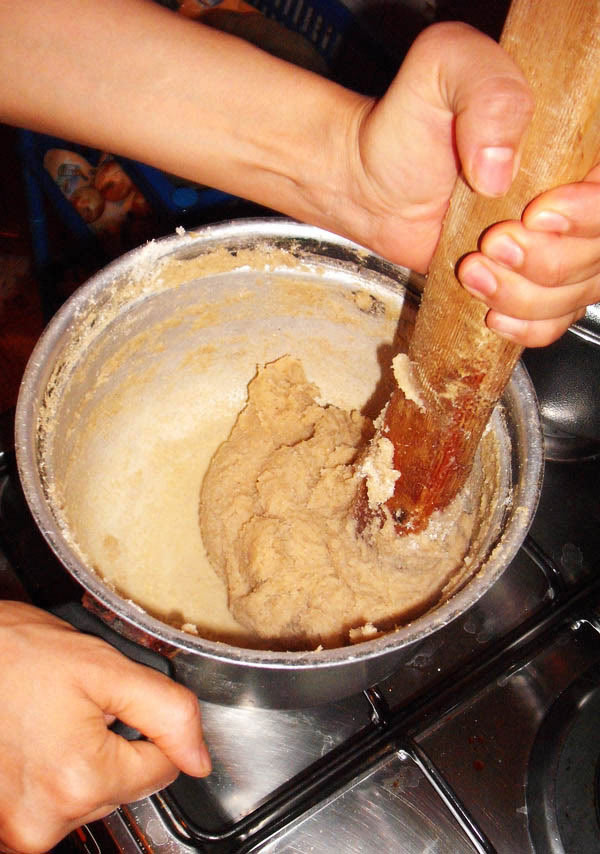 making bazin: mixing flouer in boiling water to make tough dough